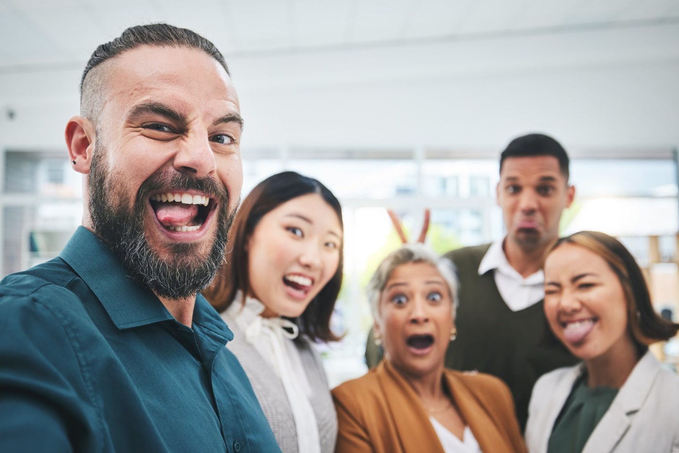 Team macht ein fröhliches Selfie im Büro